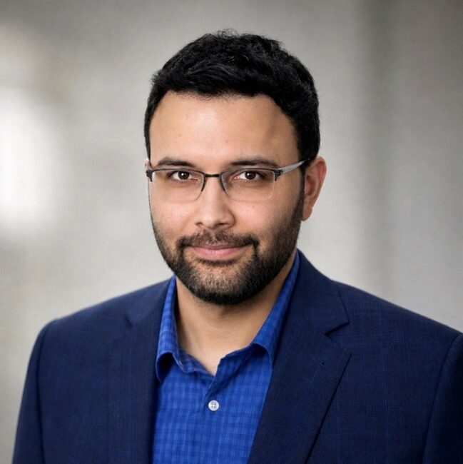 man with dark hair, beard and glasses