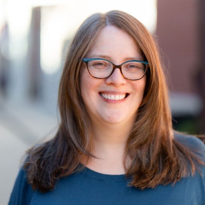 white woman with dark hair and glasses