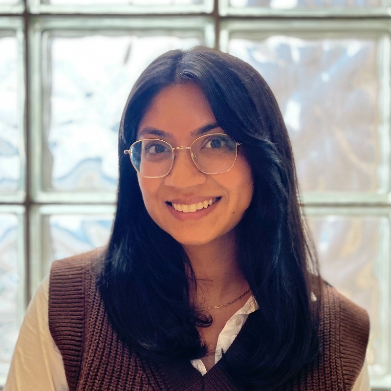 woman with dark hair and glasses