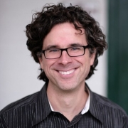 man with dark hair and glasses